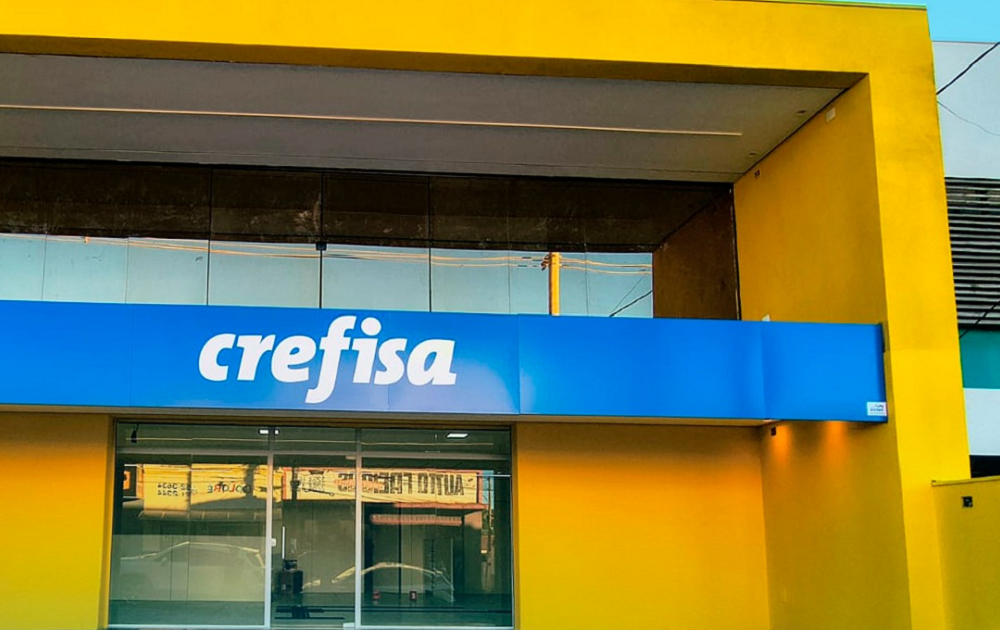 Pessoa sorrindo usando celular com logo da Crefisa